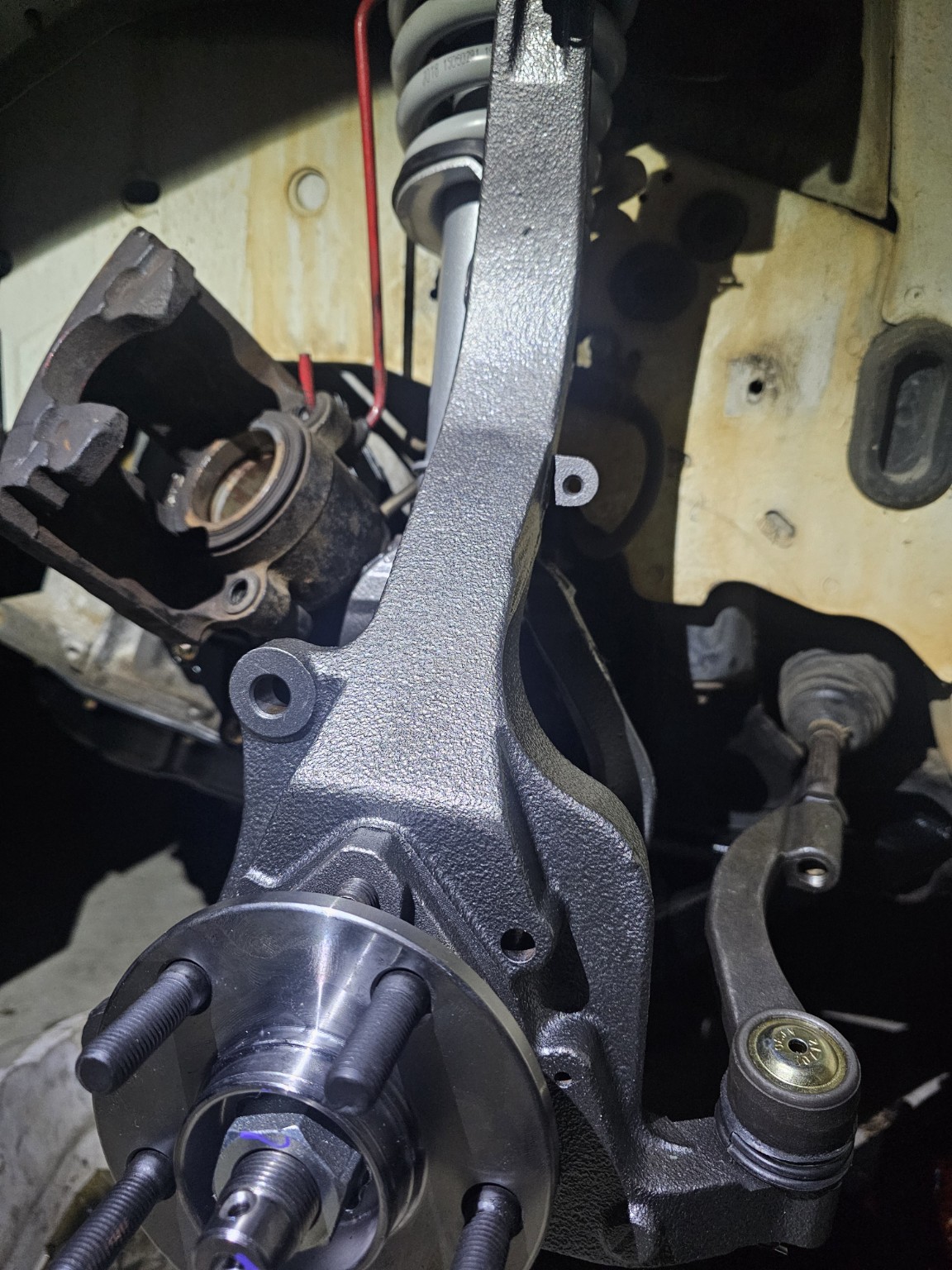 Refinished steering knuckle with a hub and suspension components